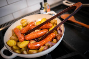 wooden salad tongs in meat and potato dish - earlywood