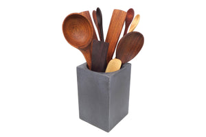 A set of wooden kitchen utensils displayed in a gray holder.