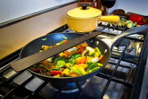 Large wood spatula sitting on pan cooking vegetables - Earlywood