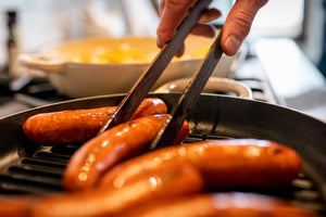 rotating brats with wooden cooking tongs by earlywood